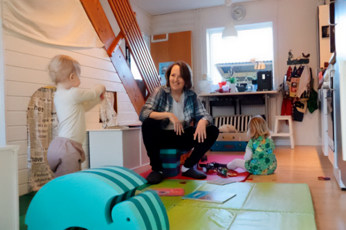 En voksen og to børn i køkkenet
