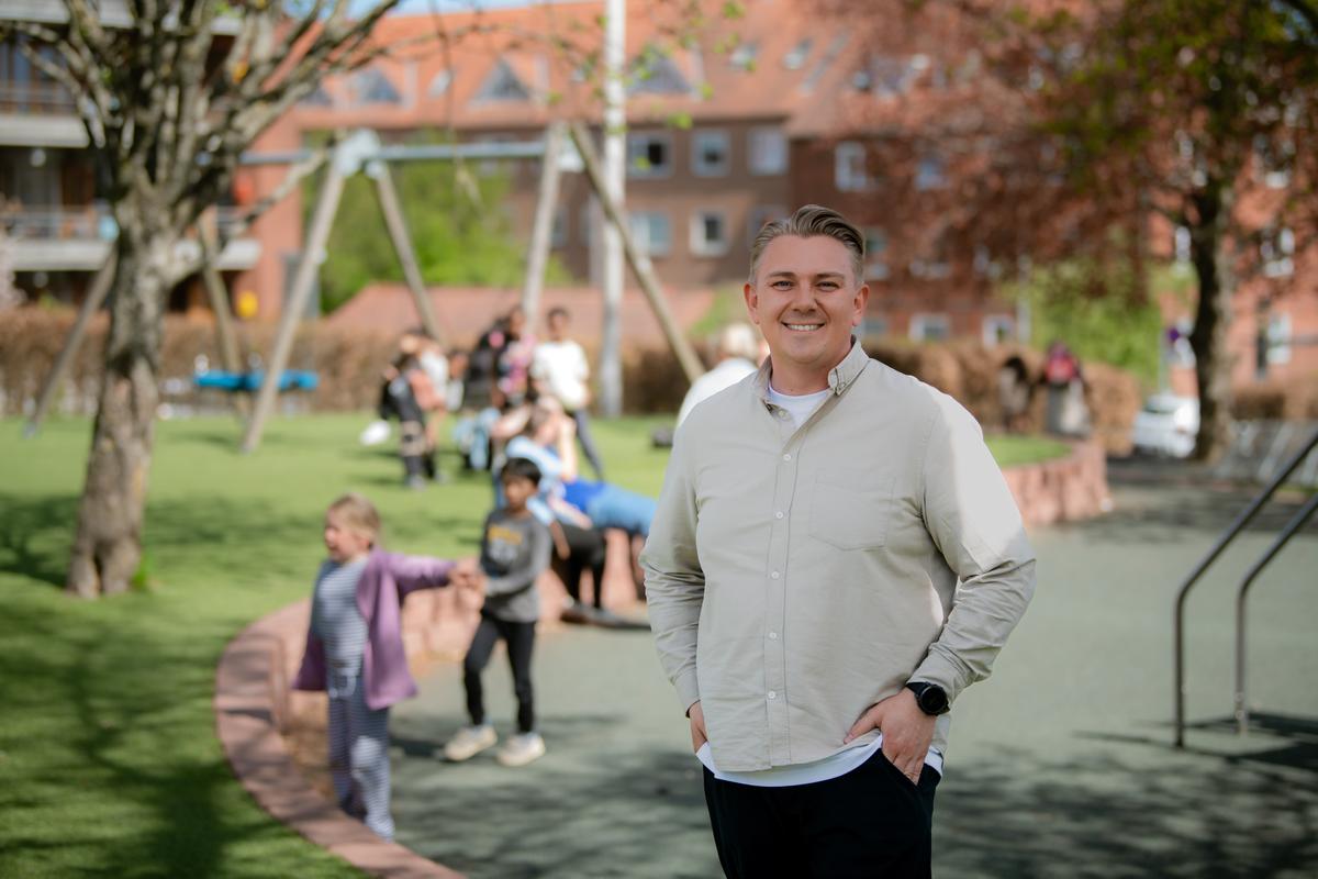 Billede af Jeppe, der står foran nogle børn - Børnene er sløret og Jeppe er i fokus