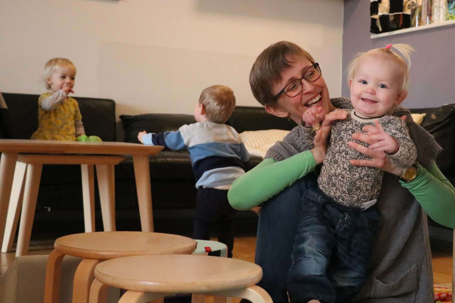 Glad pige og dagplejer hygger indenfor