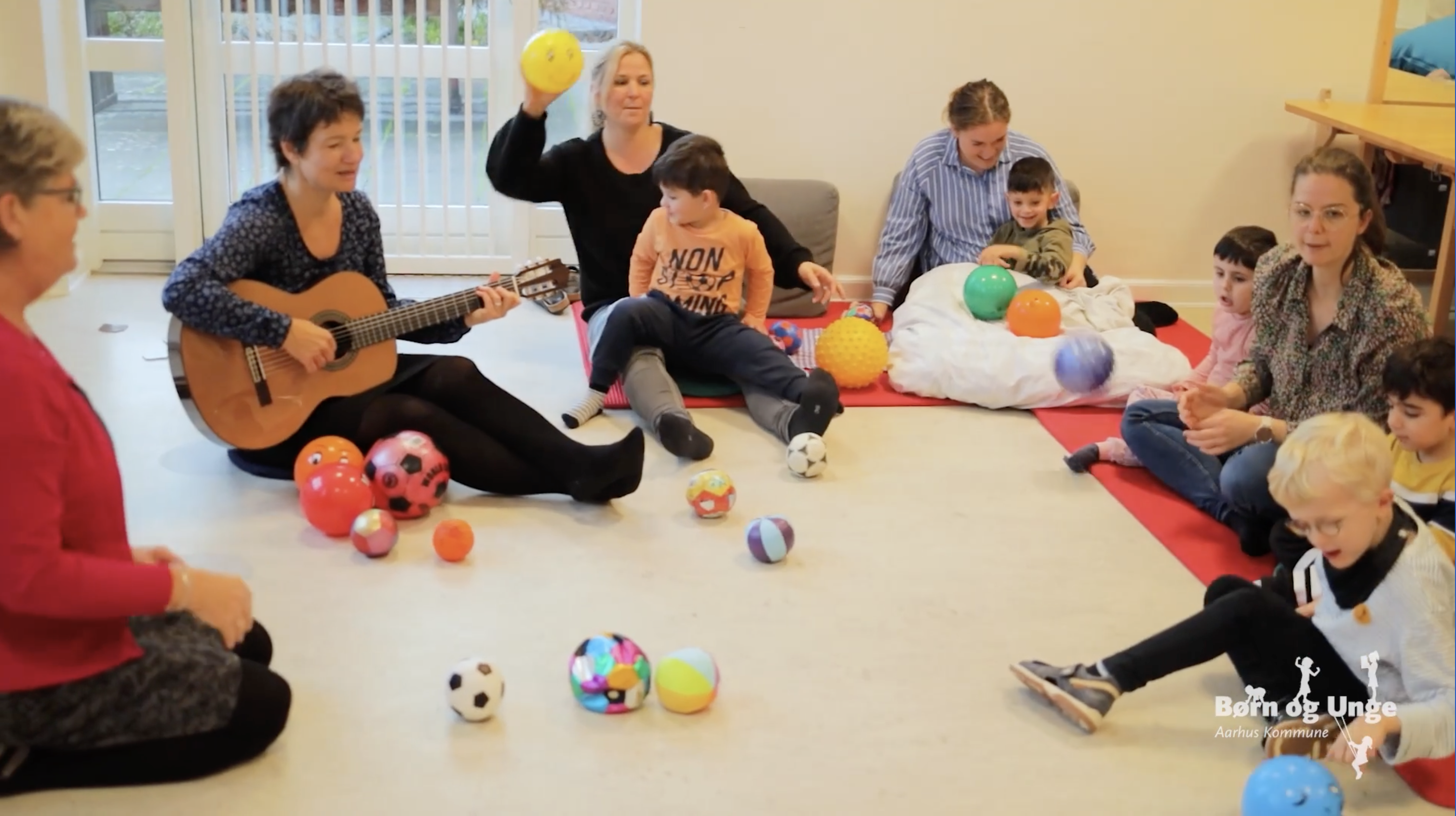 Børn lytter til musik og leger indenfor 