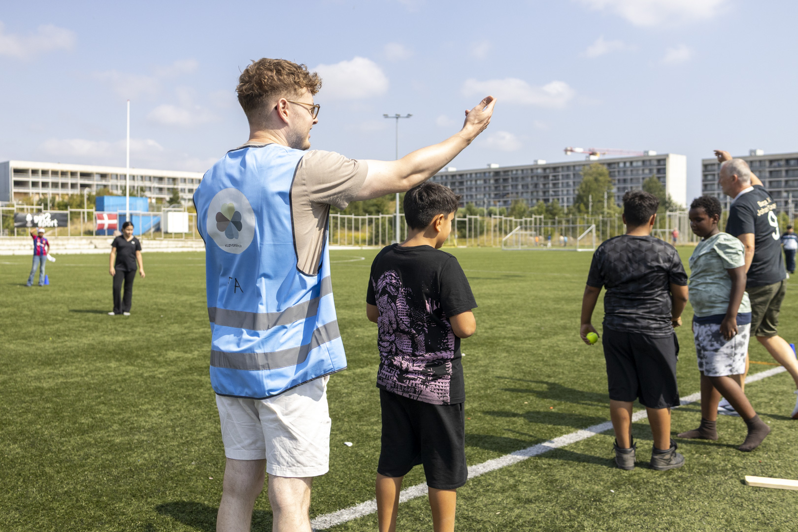 En ung mand styrer legen med en flok børn