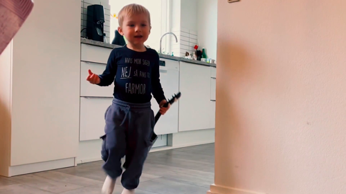 Et barn kommer gående ude fra køkkenet