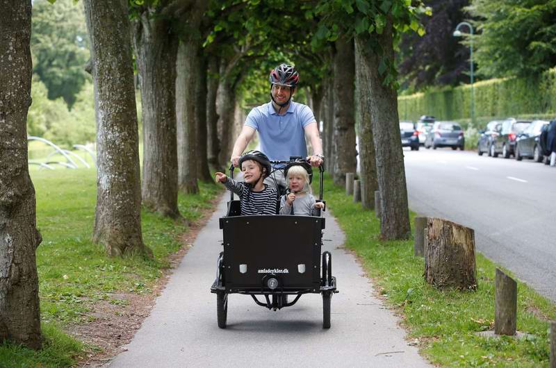 Far cykler med børn i ladcykel ved Mindeparken
