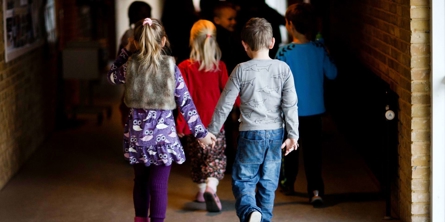 To skolebørn hånd i hånd på gangen