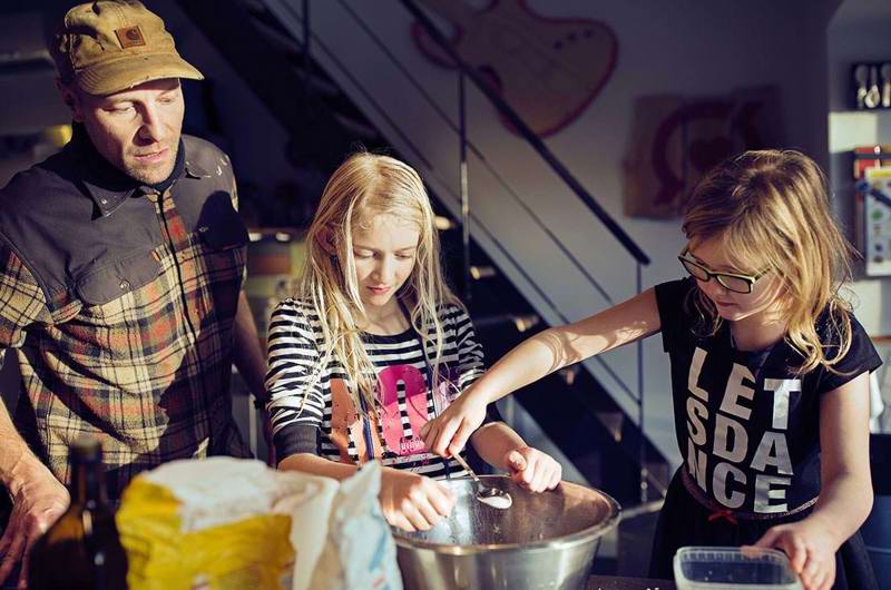 En voksen og to børn i SFO er i gang med at bage