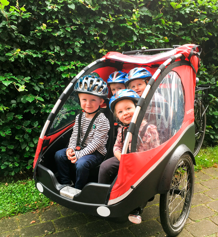 Fire børn i en cykeltrailer