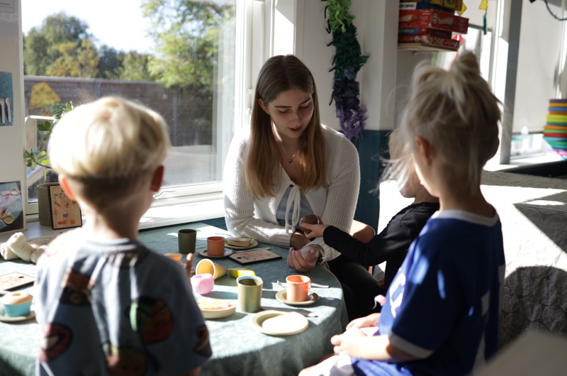 Pædagog og børn indenfor i Børnehaven Åby