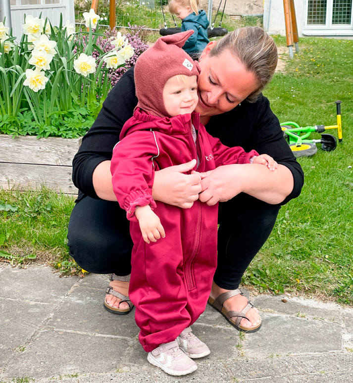 En dagplejer med en pige i flyverdragt