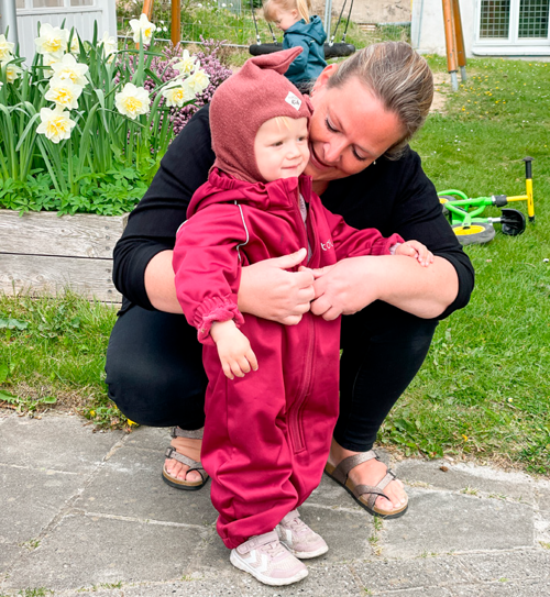 En dagplejer med en pige i flyverdragt