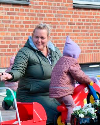 En voksen og fire børn leger udenfor